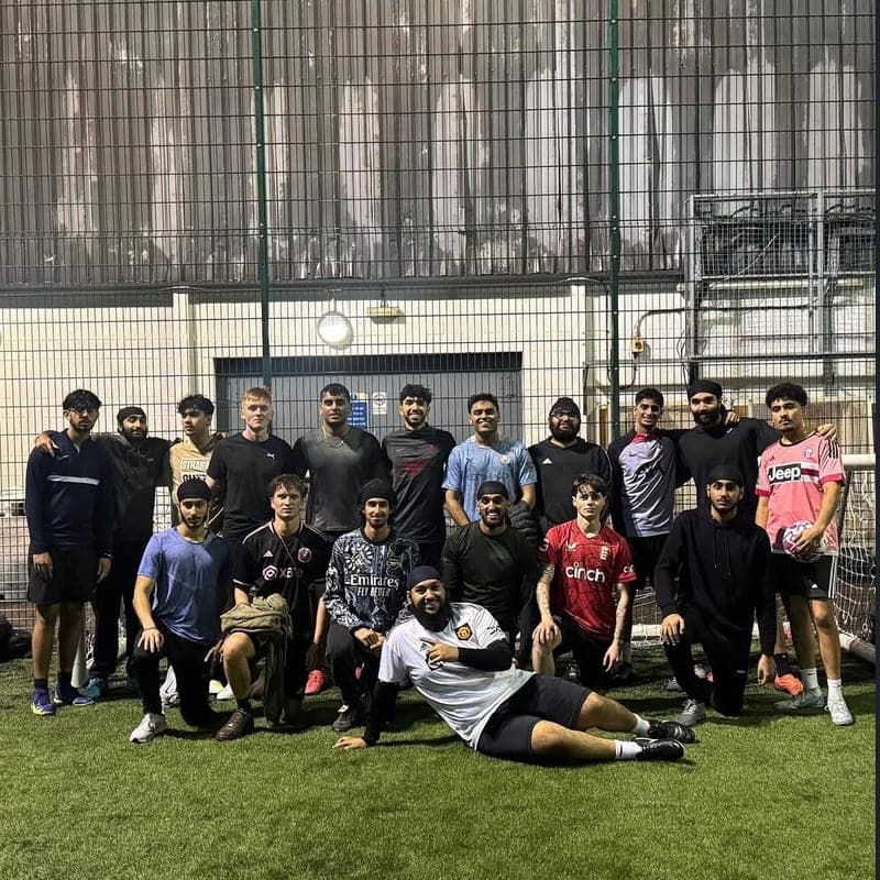 The society football squad gathered together on the pitch after a match.