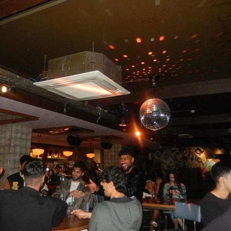 Society members together at a bar on a night out, under a mirrorball.