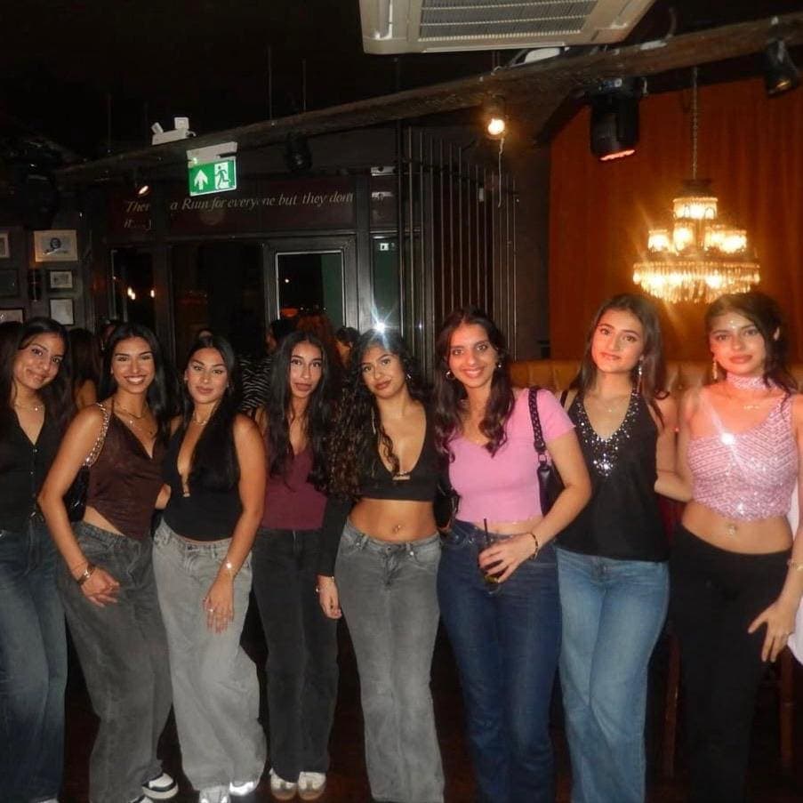 A group of members lined up for a photo on a night out at a bar.