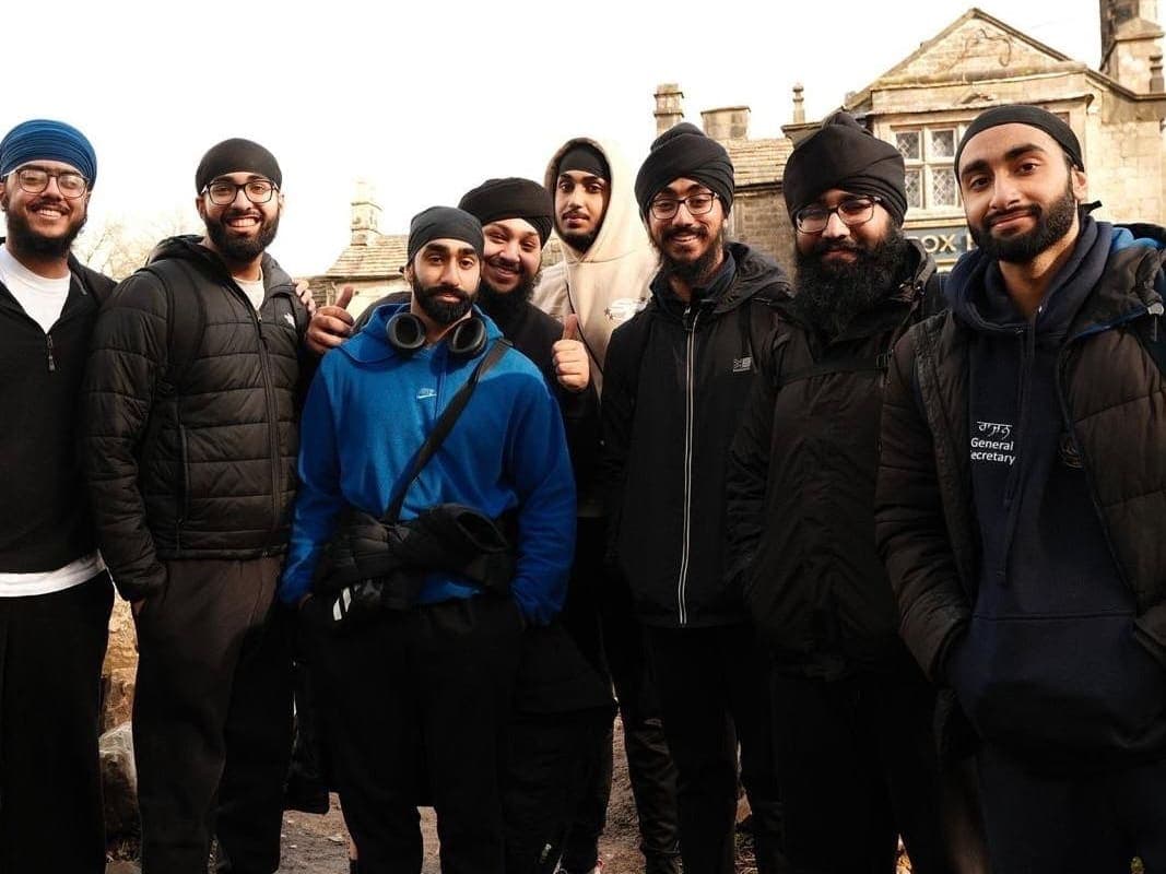 A group of members posed outside a stone building on the winter hike.